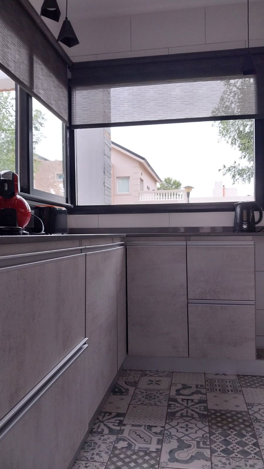 Interior con ventana esquinera y piso de baldosas calcáreas con dibujo