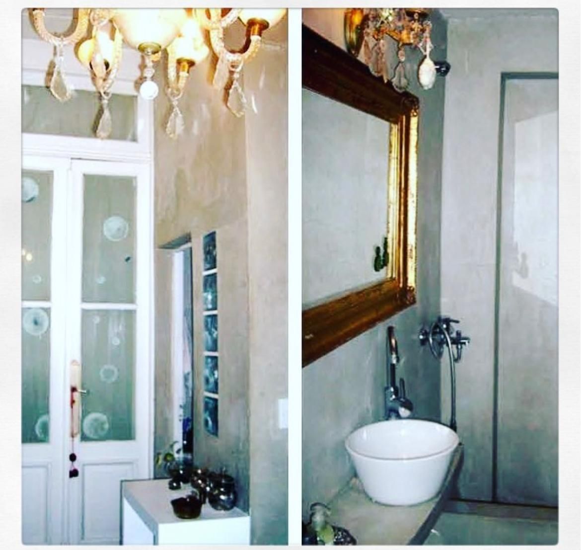 Baño con espejo de marco dorado, arañas de caireles y bacha exenta