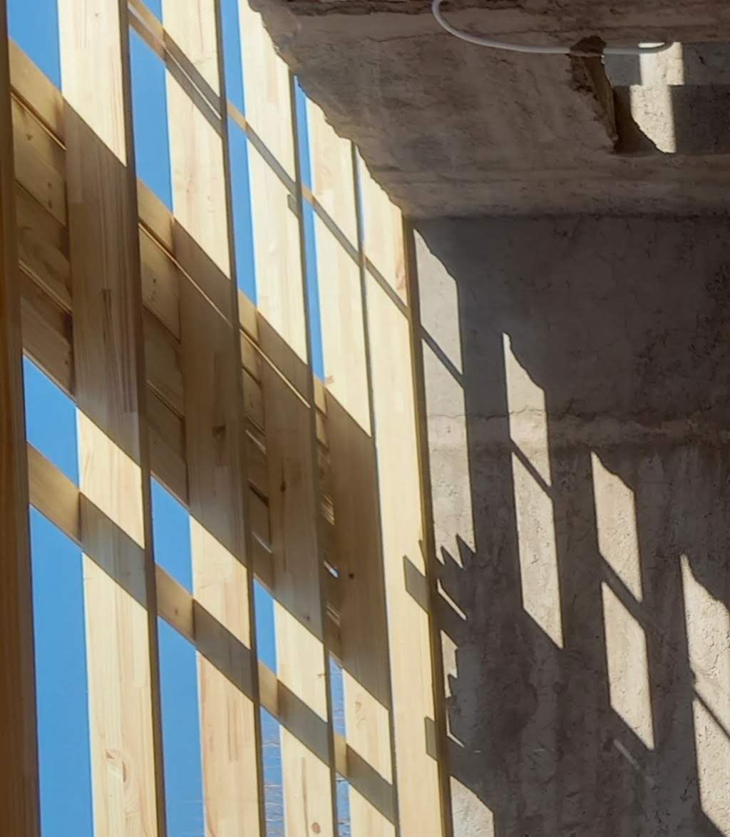 Detalle del encuentro entre el listonado de madera y el muro de hormigón